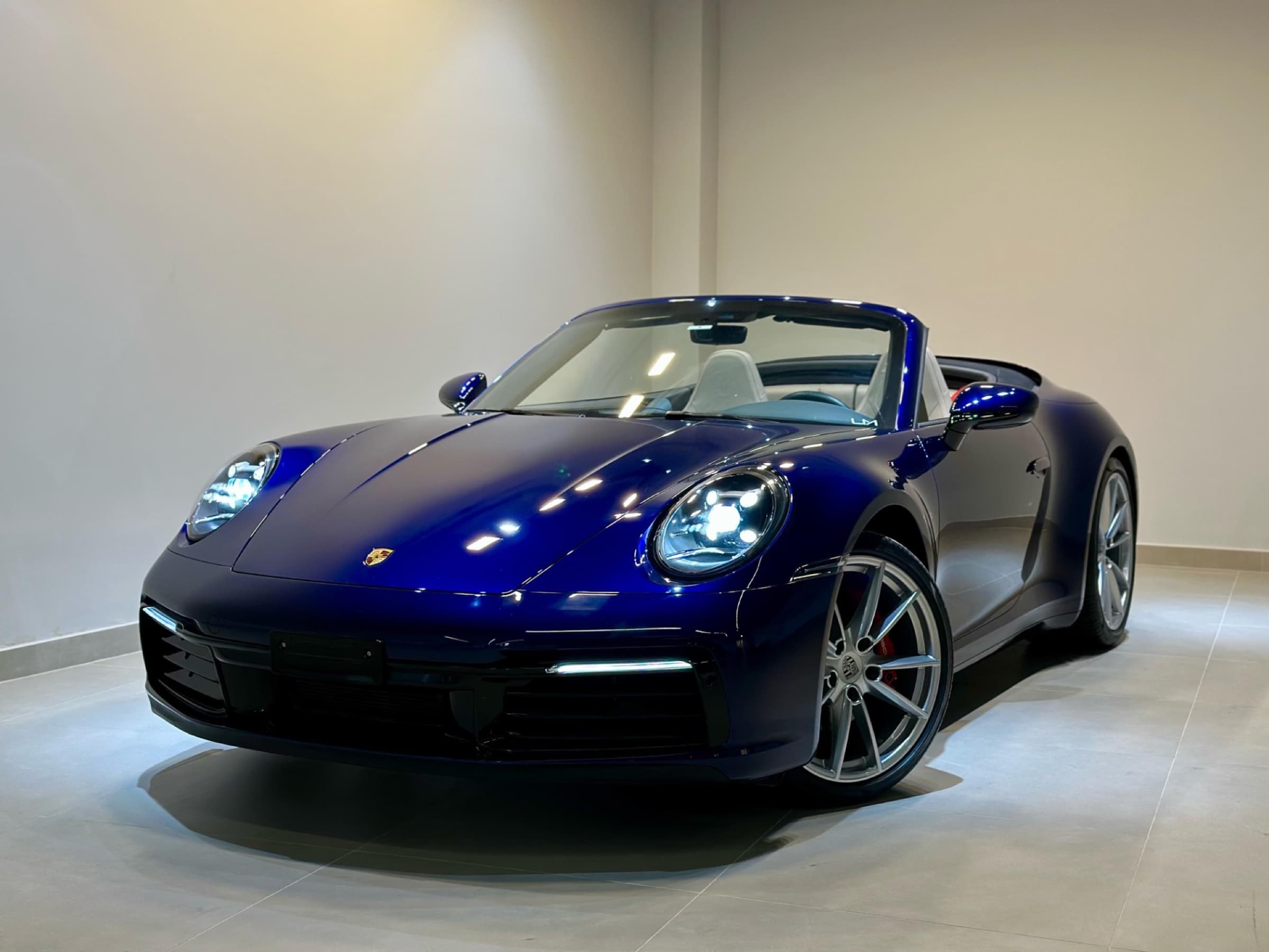 Porsche 911 Carrera Cabriolet azul no showroom LM