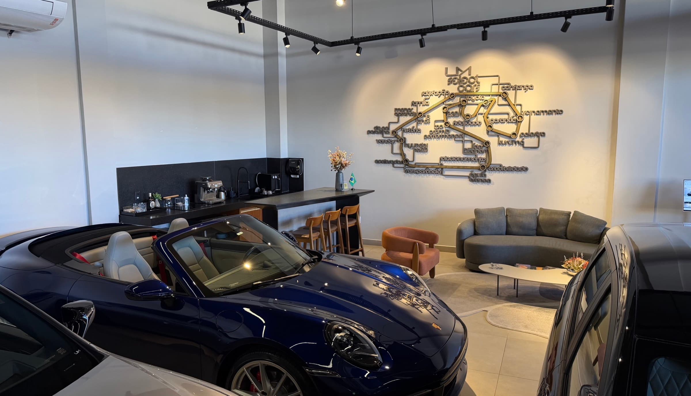 Lounge LM com sofás, bar de café e parede com valores da empresa